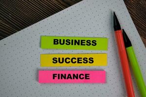 Business Success Finance write on sticky notes isolated on Wooden Table. photo