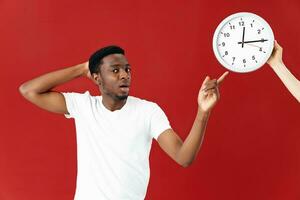 hombre de africano apariencia muestra emociones en reloj blanco camiseta estudio foto