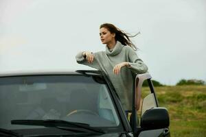 portrait of a woman with red hair in a sweater near the car nature female relaxing photo