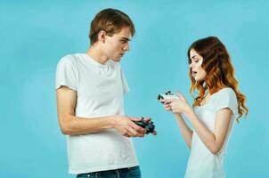 young couple in white t-shirts with joysticks in hands playing entertainment photo