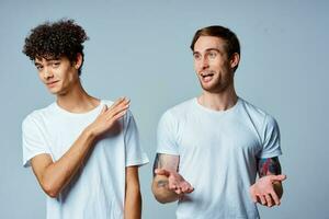 two man in white t-shirts are standing next to friendship emotions photo