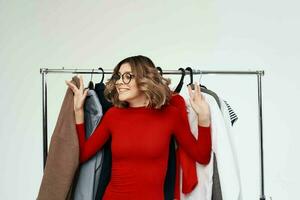 cheerful woman with glasses next to clothes fashion fun light background photo