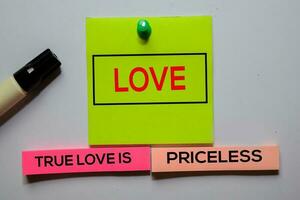 Love. True Love Is Priceless text on sticky notes isolated on office desk photo