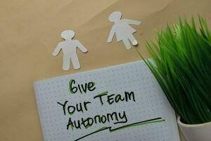 Give Your Team Autonomy write on a book isolated on office desk. photo