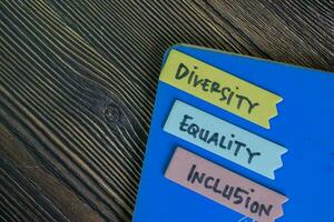 diversidad, igualdad, inclusión escribir en pegajoso notas aislado en de madera mesa. foto