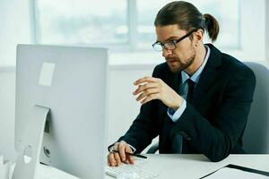 businessman sitting at a desk in front of a computer technologies photo