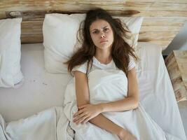 woman lying on the bed surprised facial expression top view photo