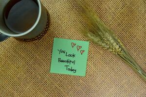 You Look Beautiful Today write on sticky notes isolated on Wooden Table. photo