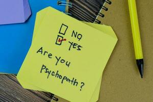 Concept of Are you Psychopath Yes write on sticky notes isolated on Wooden Table. photo