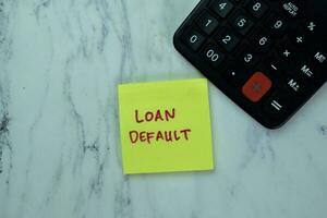 Concept of Loan Default write on sticky notes isolated on Wooden Table. photo