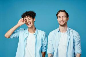 men in identical shirts and white t-shirts on a blue background chatting friends cropped view photo