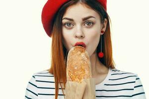 mujer en un rojo sombrero con un francés pan en su manos un bocadillo gastrónomo estilo de vida foto