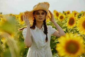 hermosa dulce niña mirando en el girasol campo inalterado foto