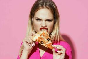 blonde eating pizza fast food pink background photo