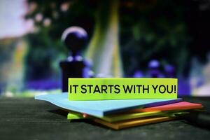 It Starts With You on the sticky notes with bokeh background photo