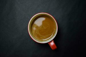 Close up Red cup with Coffee Cappucino on black table photo