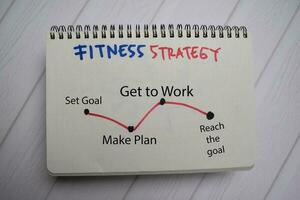 Fitness Strategy write on a book and keyword isolated on Office Desk. photo