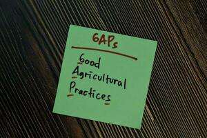 GAPs - Good Agricultural Practices write on a book isolated isolated on Wooden Table. photo