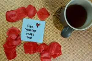 Give Yourself More Time write on sticky notes isolated on Wooden Table. photo