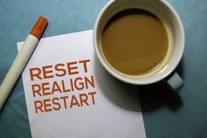 Reset Realign Restart text on the paper isolated on office desk background photo