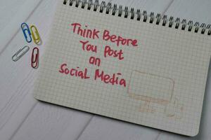 Think Before You Post On Social Media write on a book isolated on wooden table. photo