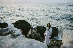 Beautiful woman walks volcanic rock formations on the island relax photo