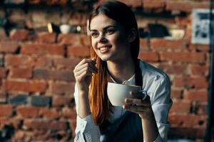 mujer con un taza de café cerca el mesa camarero Servicio trabajo profesionales foto