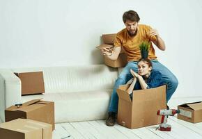 Housewarming couple moving to a new apartment boxes with things photo