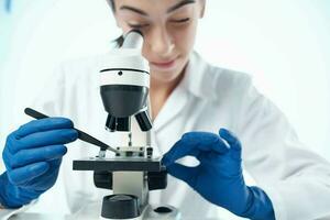 female laboratory assistant looking through a microscope research science technology photo