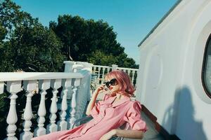 beautiful woman with pink hair wearing sunglasses posing Relaxation concept photo