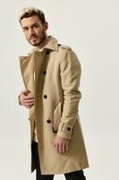 handsome blond man in beige coat and shirt bent over to the side cropped view photo