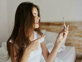 cheerful woman shows the temperature on the thermometer is normal photo