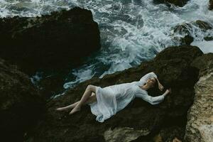 beautiful woman Lies on his back on a stone cliff cloudy weather view from above photo