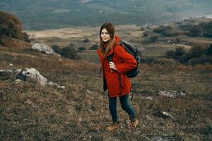 mujer en un chaqueta con un mochila montañas estepa paisaje otoño calentar ropa modelo foto