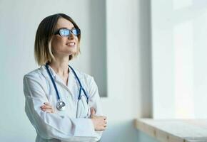 professional doctor woman with glasses near window and stethoscope photo