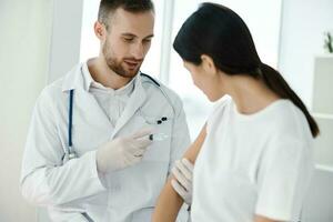 young doctor inject vaccine into patient's shoulder and syringe in hand with stethoscope laboratory photo