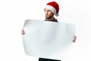 Cheerful man in a christmas hat with white mockup poster christmas copy-space studio photo