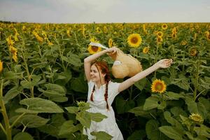 hermosa dulce niña mirando en el girasol campo inalterado foto