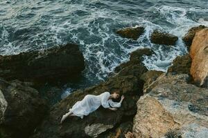 Barefoot woman in white wedding dress on sea shore wet hair landscape photo