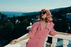 fashionable woman with pink hair wearing sunglasses posing sunny day photo