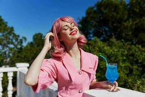 retrato de hermosa mujer con rosado pelo verano cóctel refrescante bebida Bebiendo alcohol foto