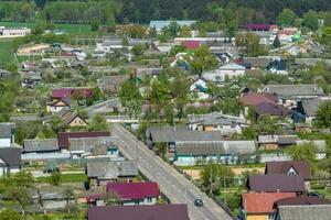 panoramic aerial view of eco village with wooden houses, gravel road, gardens and orchards photo