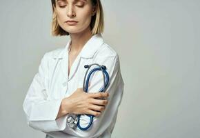 mujer en blanco Saco médico y estetoscopio en mano foto