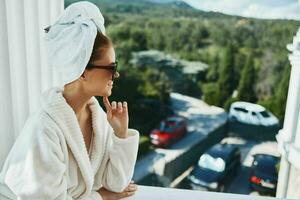 Portrait woman in a bathrobe in the morning on the balcony admiring nature unaltered photo