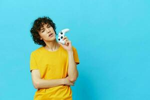 man plays with joystick in yellow t-shirts technologies photo