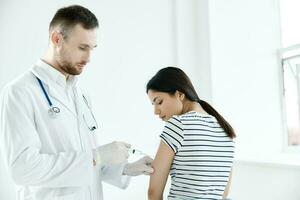 male doctor giving an injection to a patient in a hospital coronavirus photo