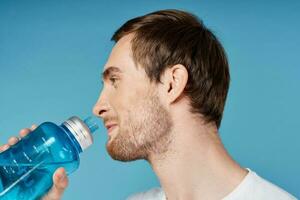man drinking water from blue bottle fitness workout thirst photo