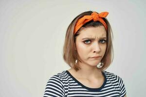 pretty woman with a bandage on her head in a striped t-shirt light background photo