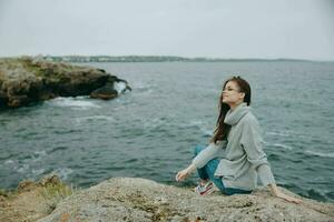 woman sweaters cloudy sea admiring nature Relaxation concept photo