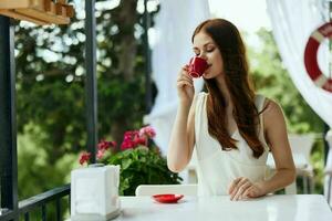 cheerful woman sitting in outdoor cafe street drink coffee Summer day photo